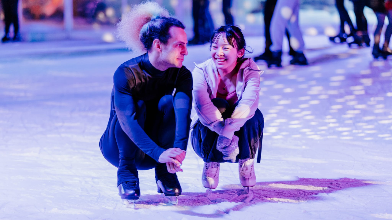 Friends ice skating at night during the Winter in the City Whiteout Party