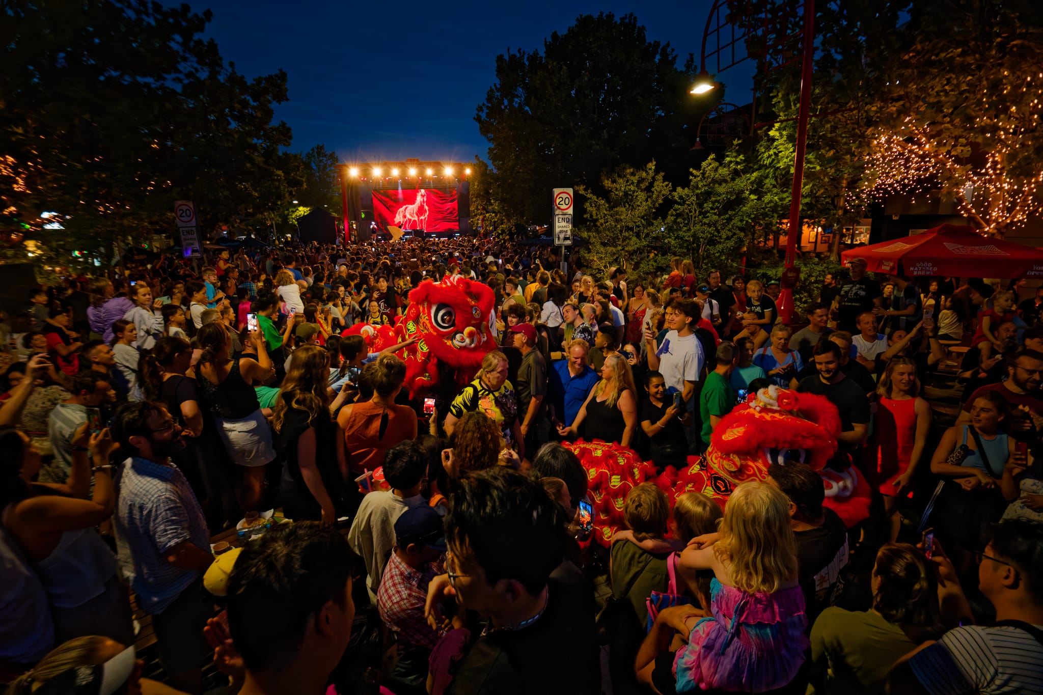 A crowded street at night in Dickson of people celebrating Lunar New Year with colour and vibrancy