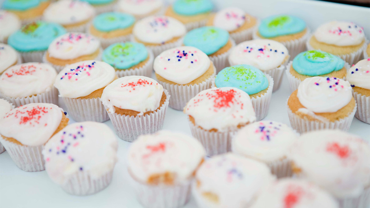 Iced homemade cupcakes spread out out a tray.