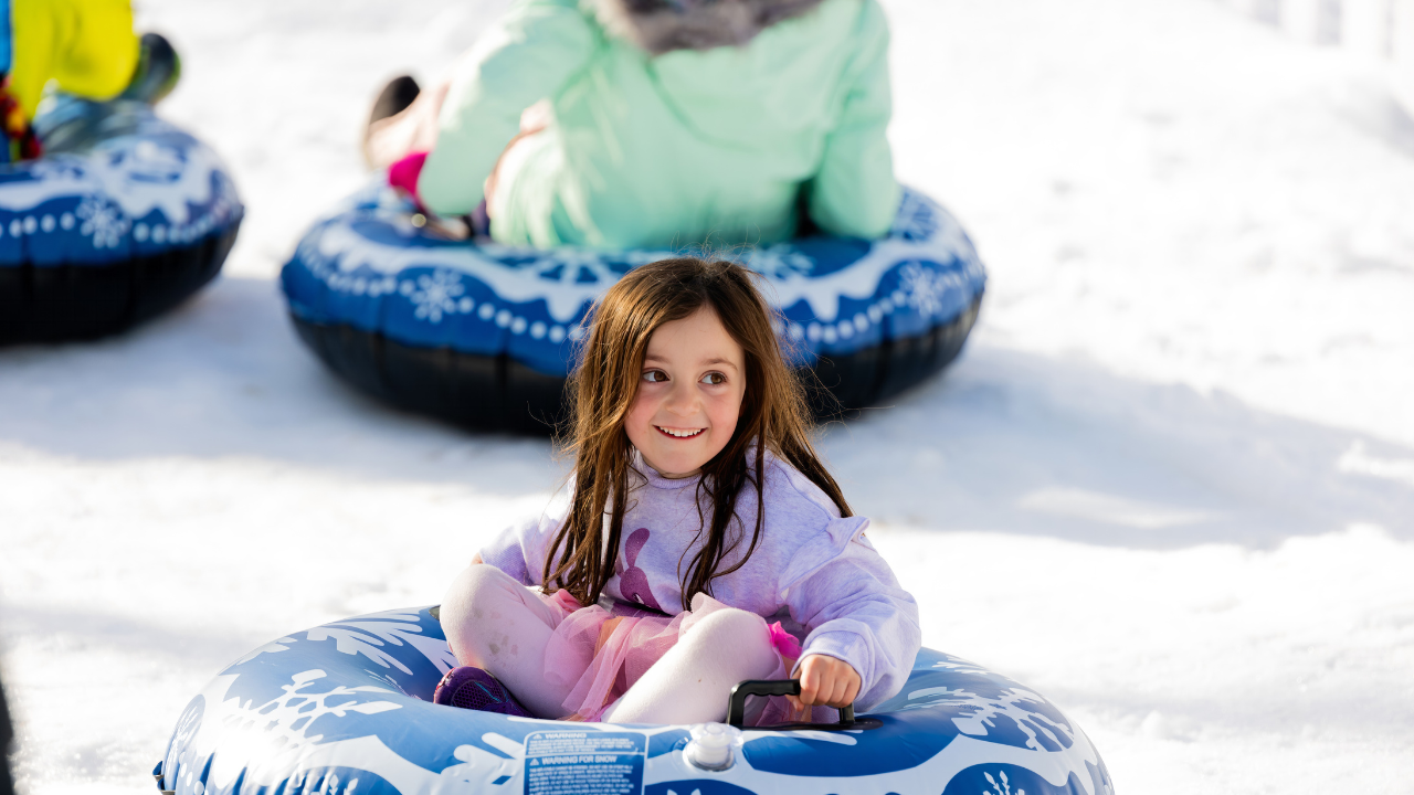 A young girl smiles as she toboggans down the 8m slide at Winter in the City