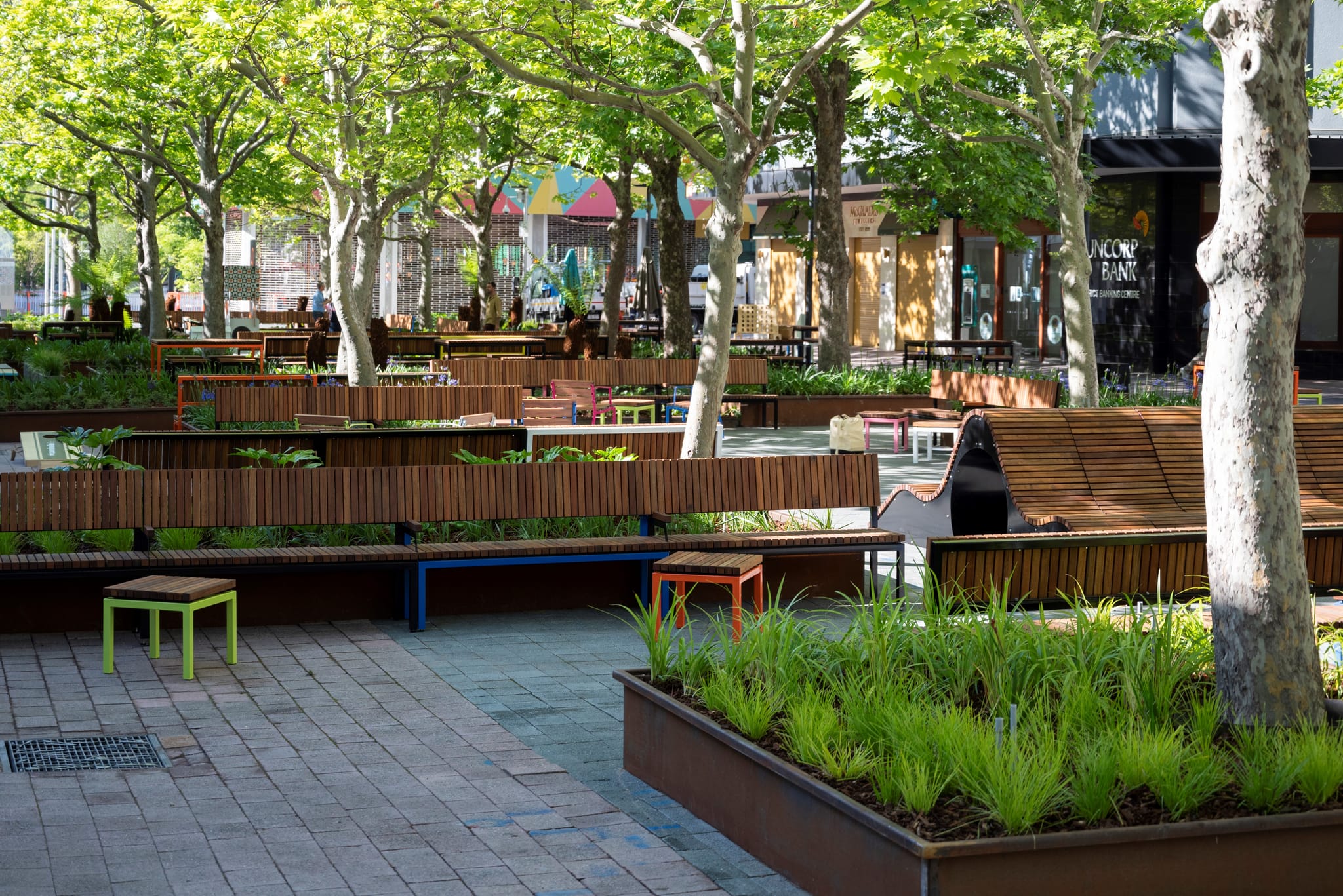 Image shows the bench seating and landscaping that was introduced as part of the most recent City Walk upgrade with the merry go round in the background.