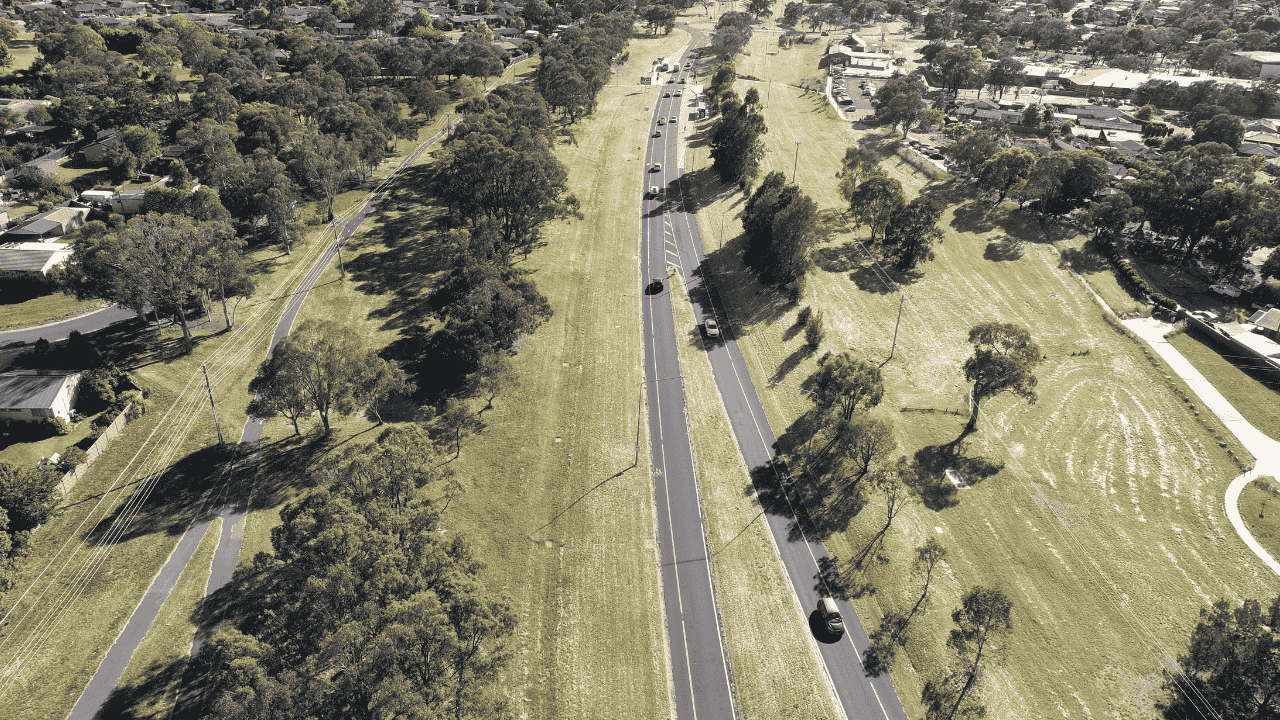 A birdseye view of a busy road with surrounding greenery.
