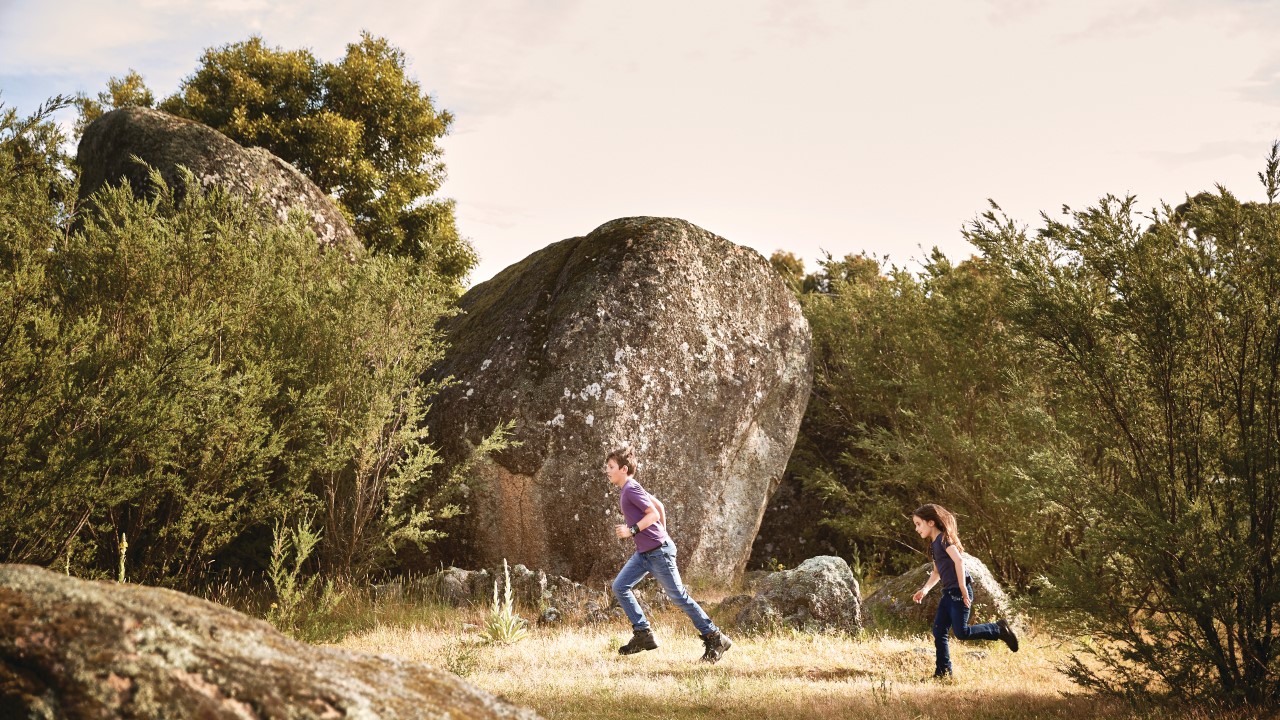 Children running through grasslands at Tidbinbilla Nature Reserve