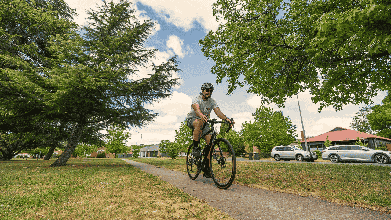 A person in a helmet rides a bike outside.