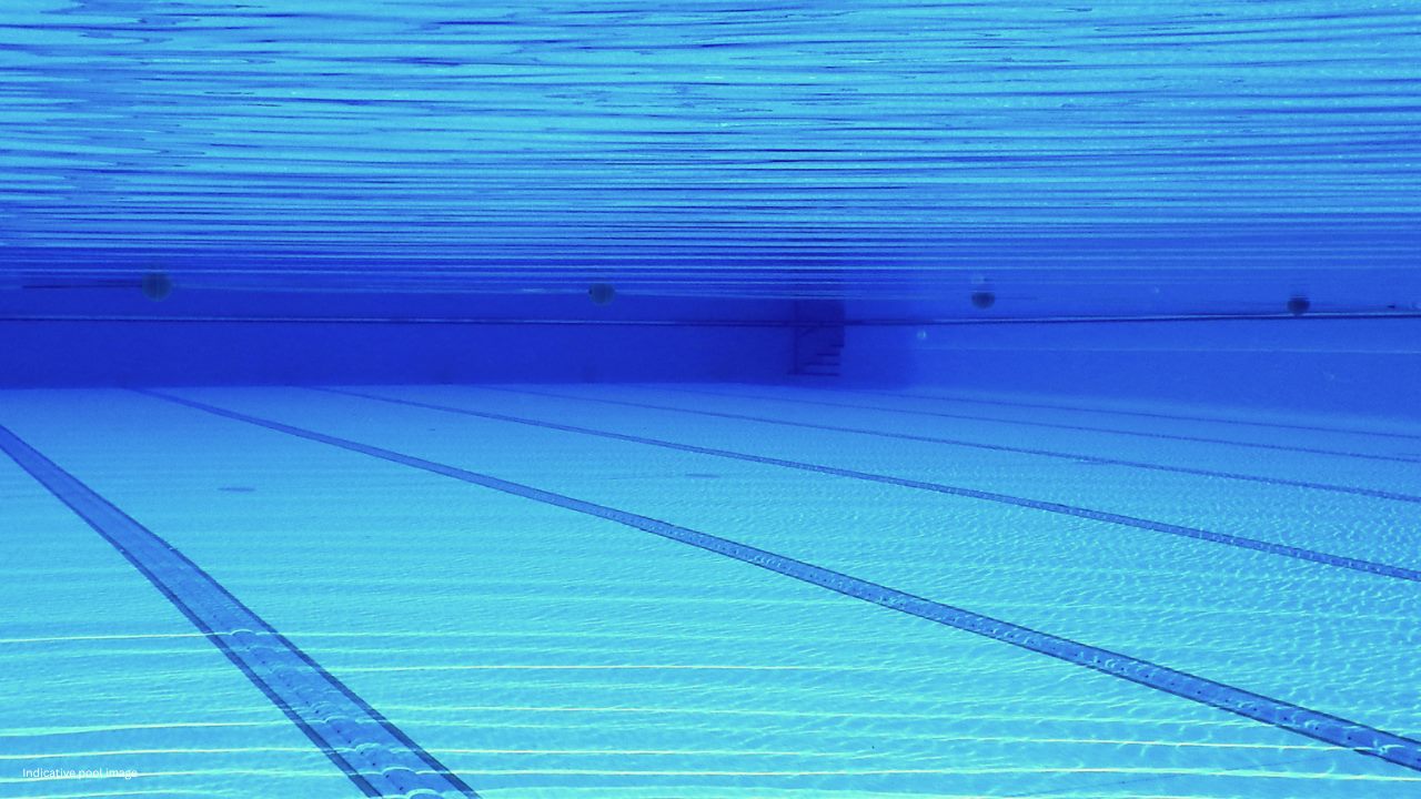 An underwater photo taken in a blue public pool.