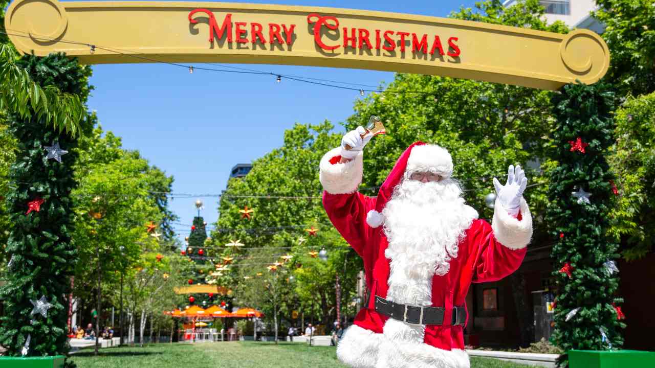 Santa in front of a archway that reads 
