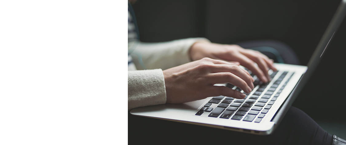 Hands typing on a laptop