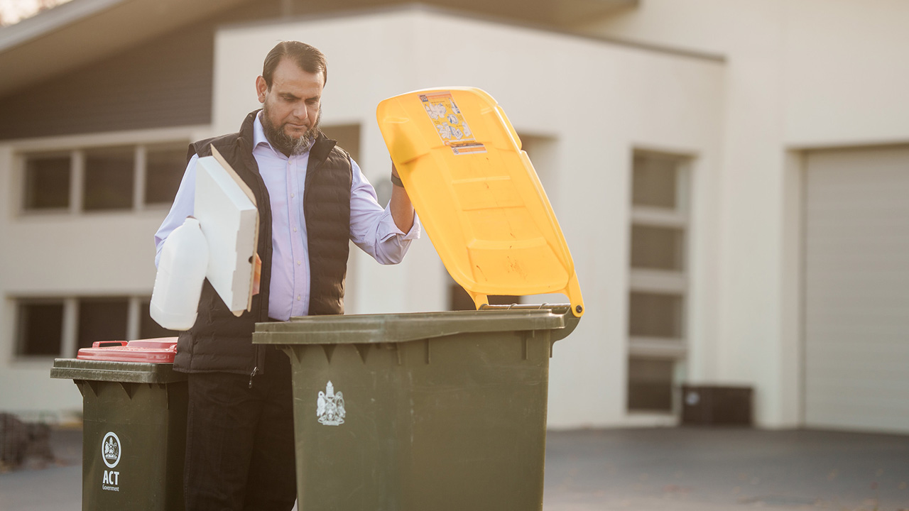 A person opens a bin lid.