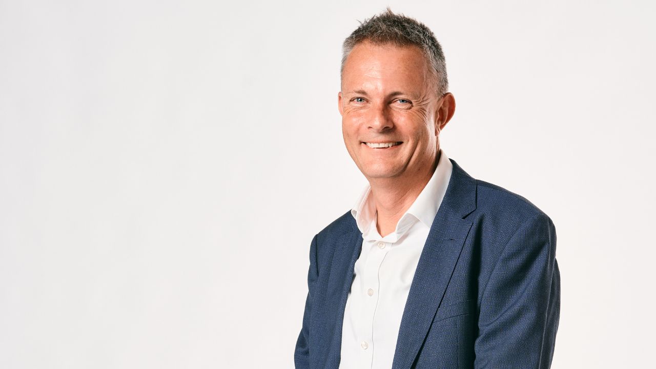 Image of man wearing blue suit smiling. 