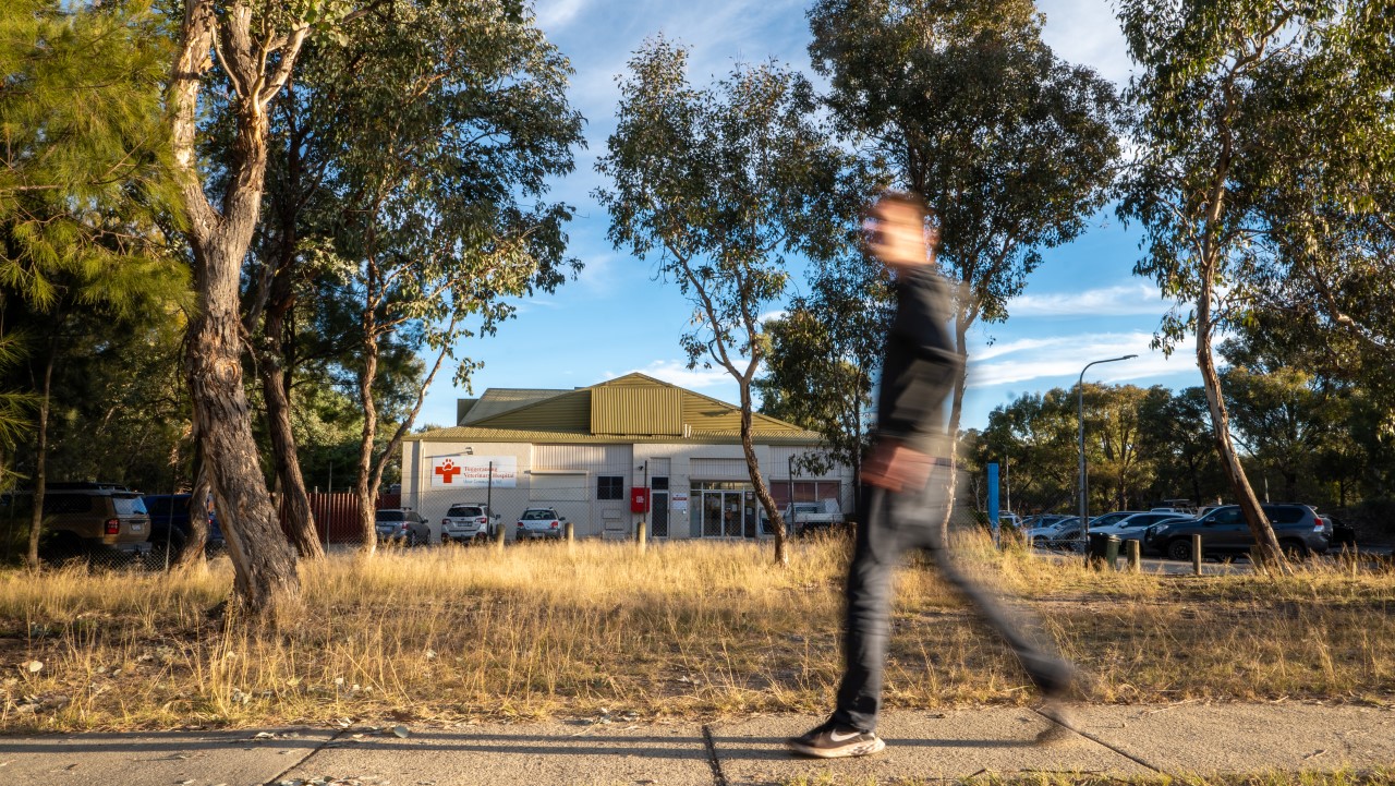 Man walks past Fadden shops where neighbourhood-scale battery site is going
