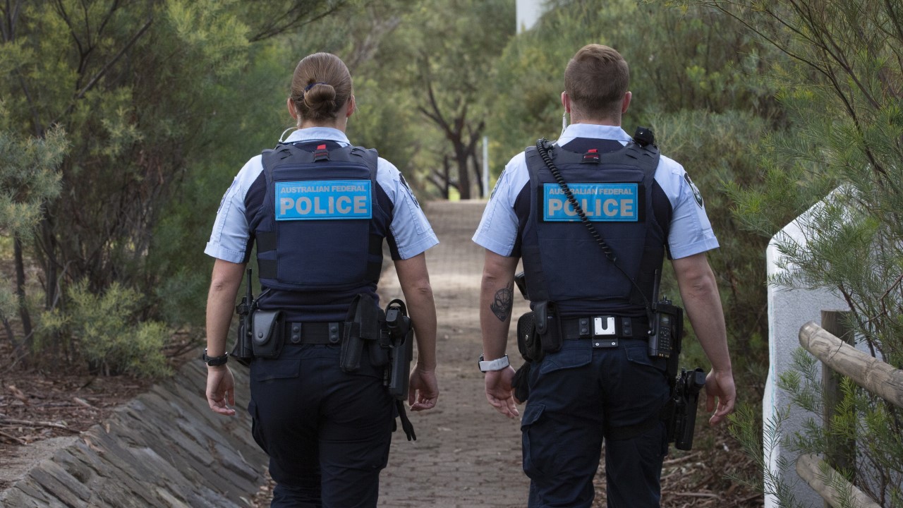 ACT Polce officers walking down Tuggeranong foot path side by side