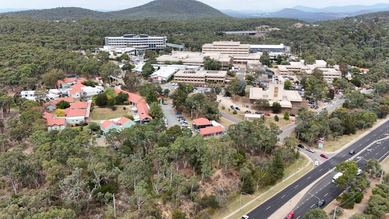 An overhead image of a hospital campus surrounded by bushland.