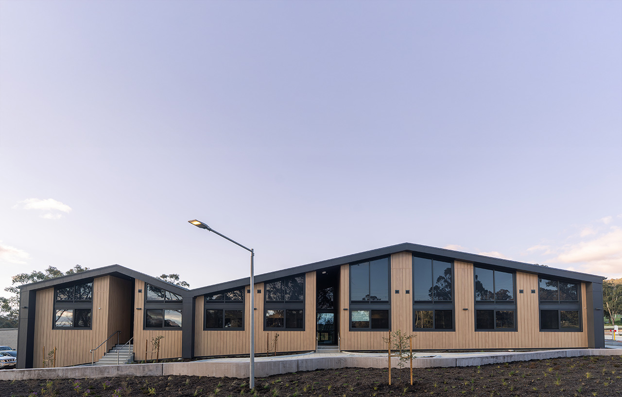 A newly built building set against blue sky. There are lots of windows and new landscaping.