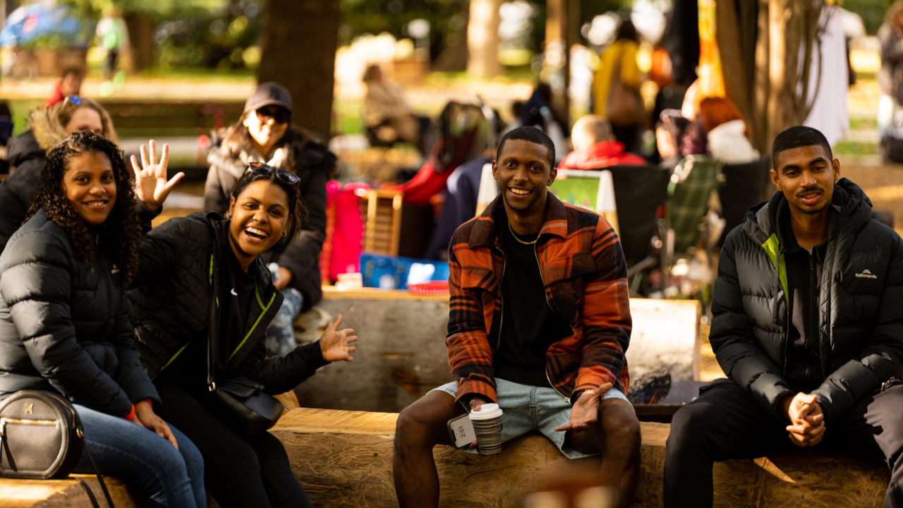 A group of friends enjoying live jazz music played in the park as part of nearby Tree Week activities