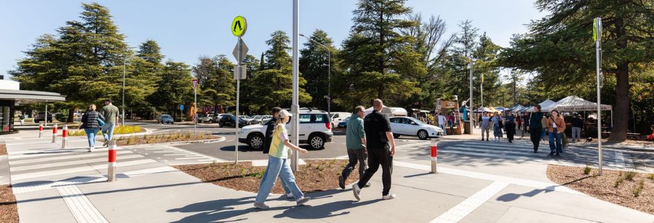 People walking on pedestrian crossing at the north end of Lonsdale Street.