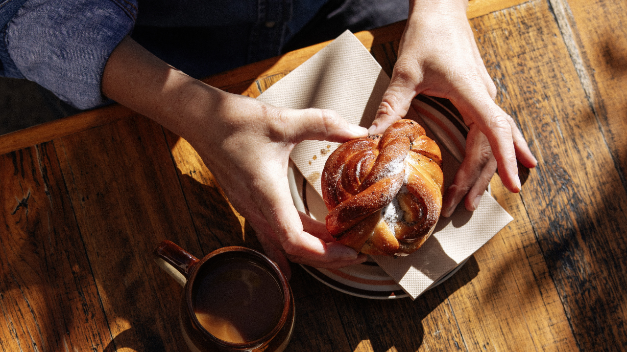 Person holding a cinnamon scroll
