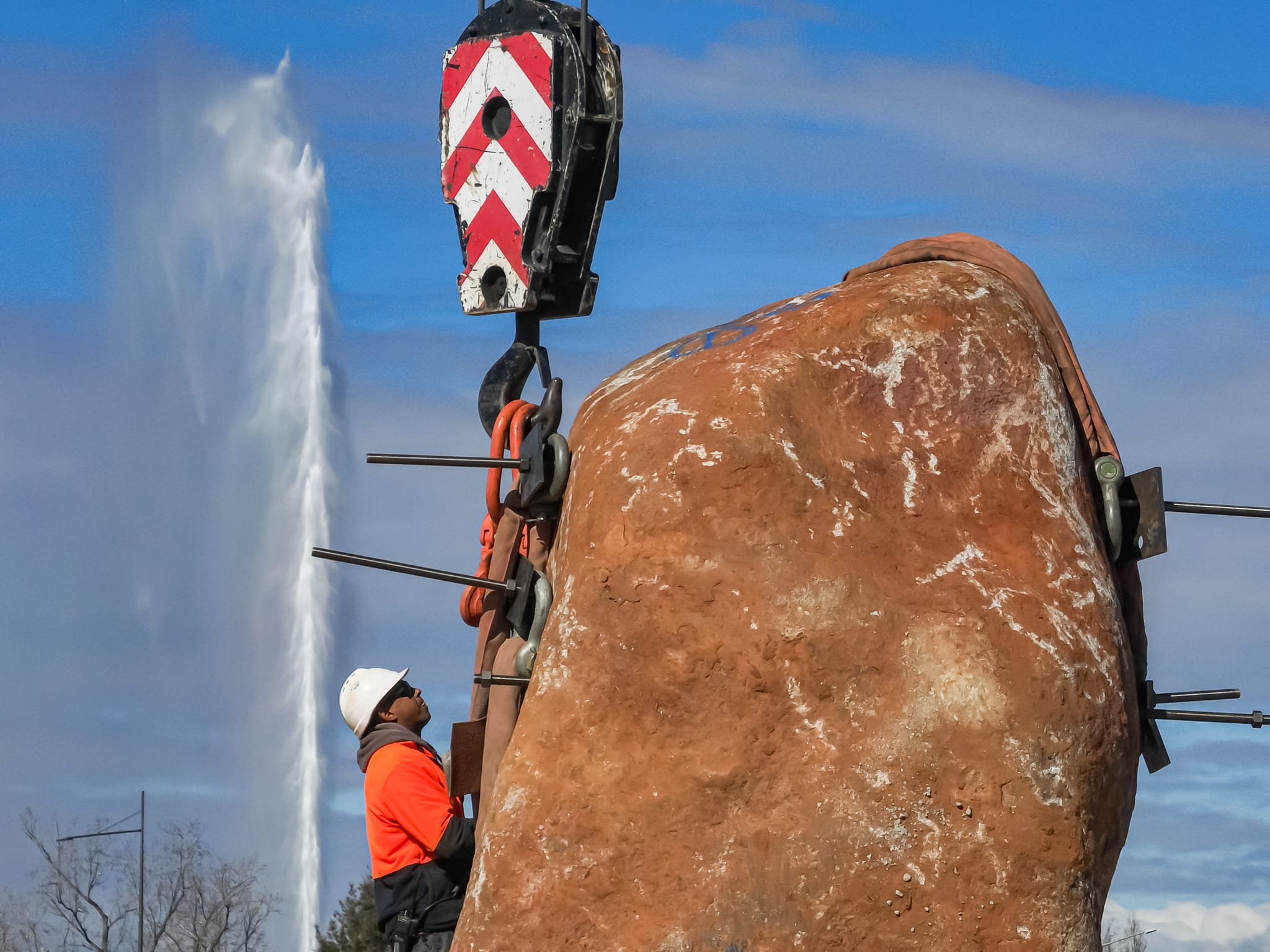 Ngamawari park boulder installation with large rock, worker and fountain in background