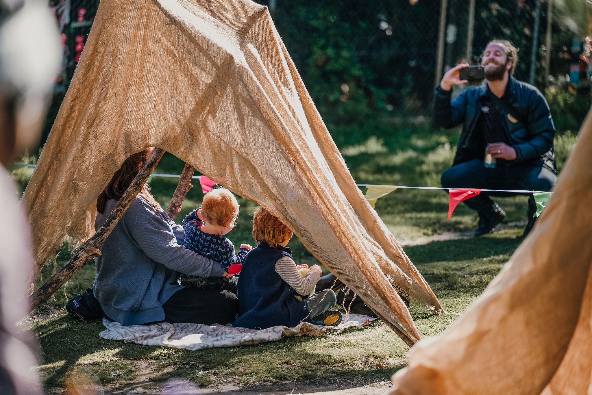 A family poses for a photo as they enjoy a creative activity at an event in Haig Park