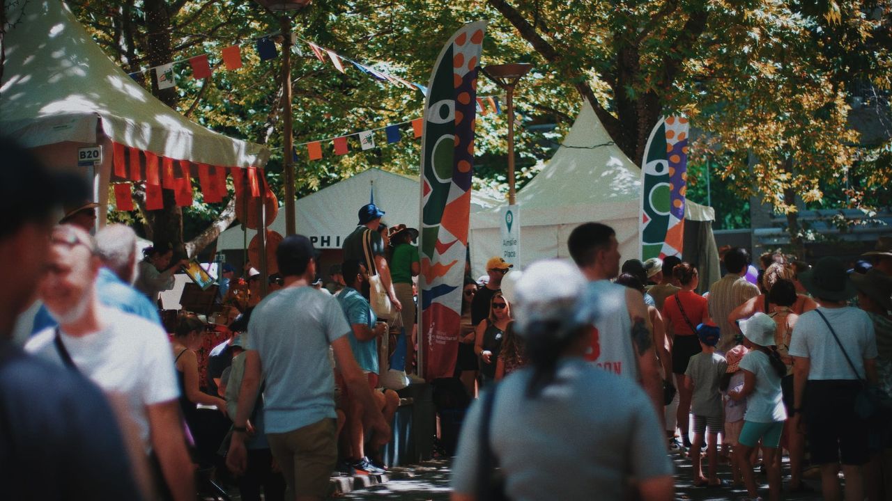 Crowds in a city with colourful signage. 