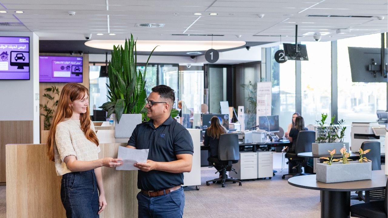 Man and women talk in an office environment.