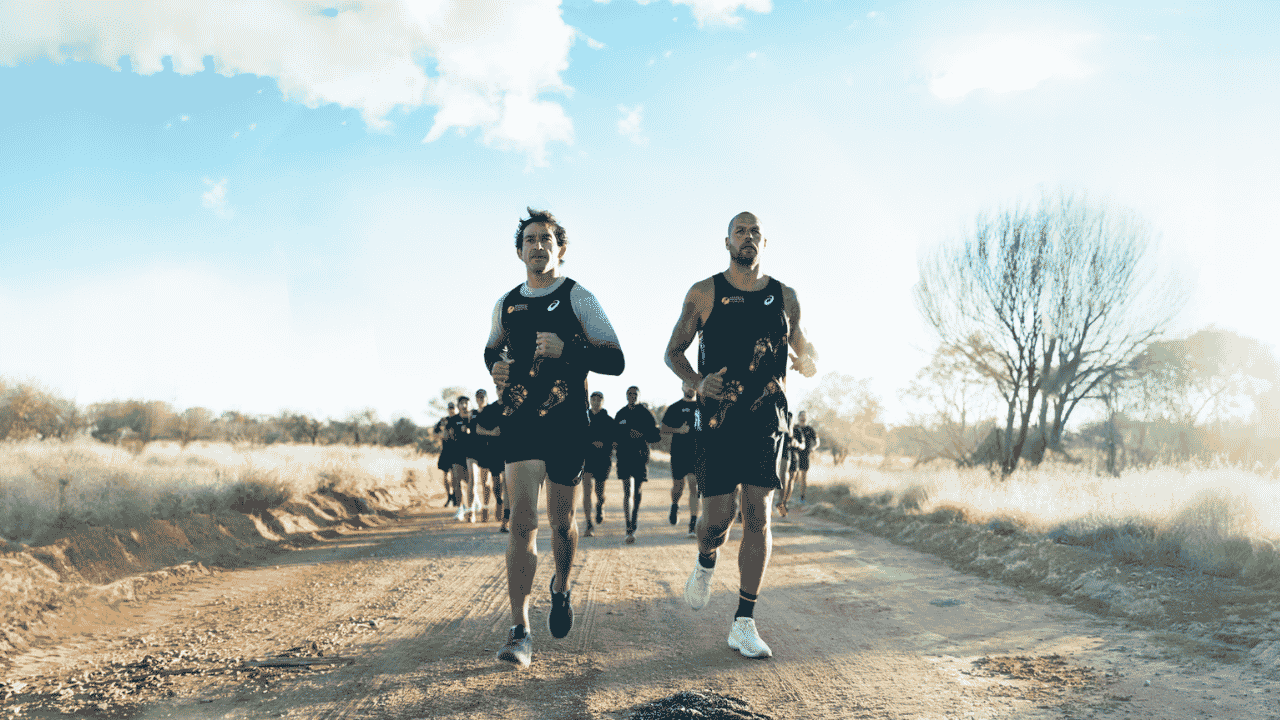 two people run on a dirt track