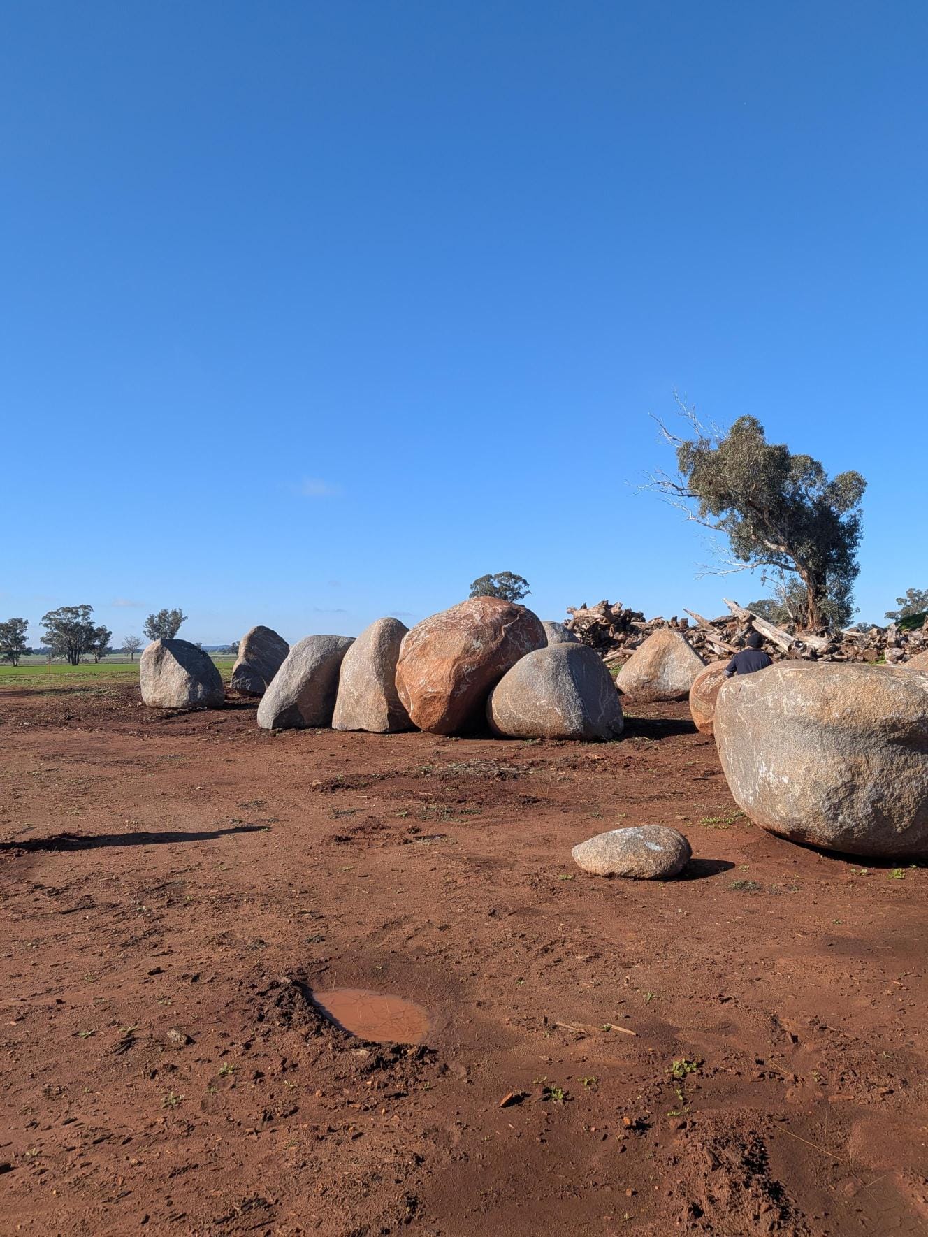 Ngamawari park boulders in Forbes with muddy ground, large rounded rocks and tree in background