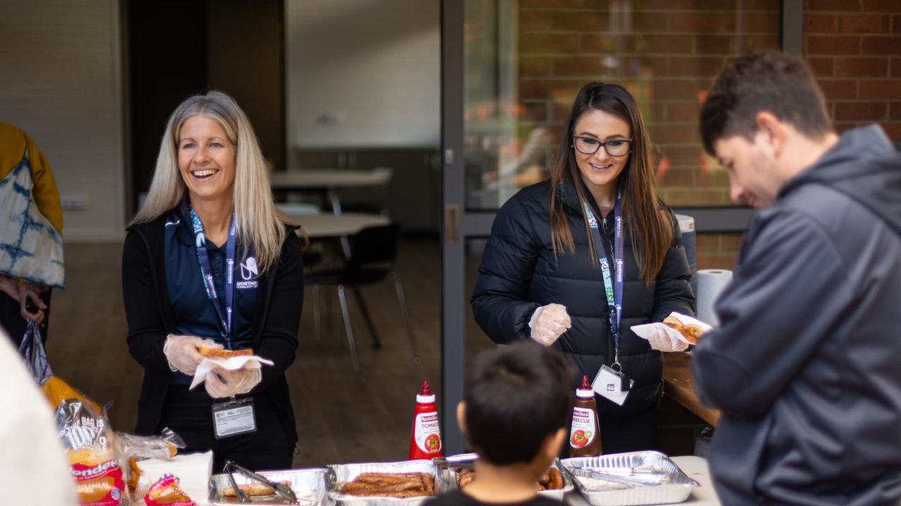 Northside Community Service staff members running a BBQ at the Salthouse Community Centre Welcome Day