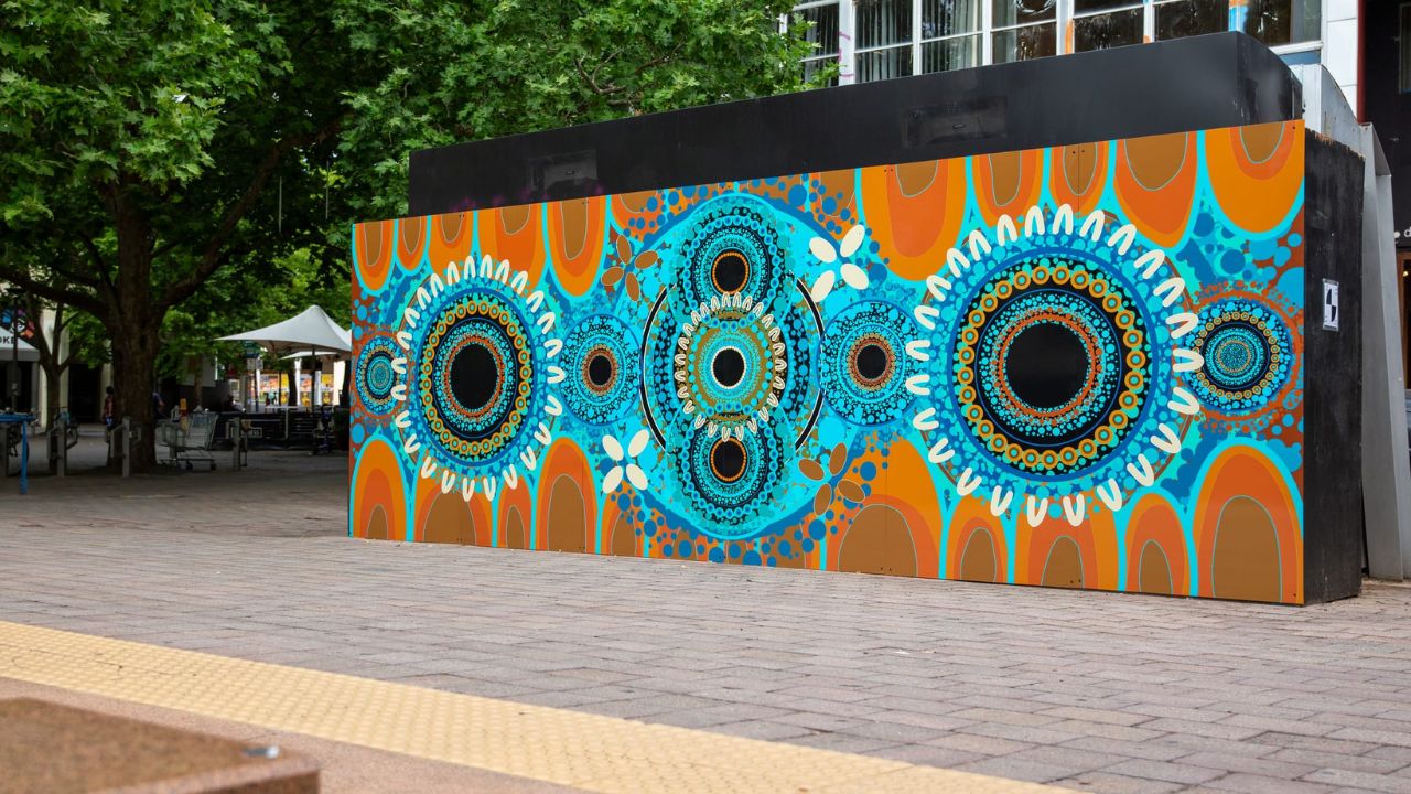 Orange, blue and white First Nations mural in Garema Place. 