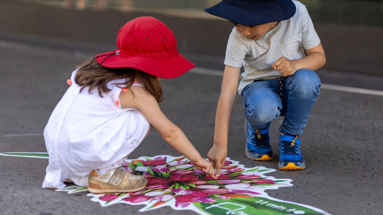 Children play near one of the floral ground stickers providing wayfinding along the Floriade Walking Trail