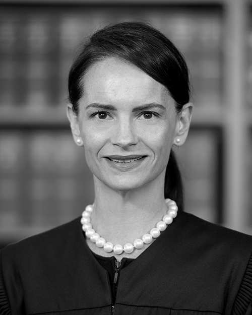 A black and white photo of a woman with dark hair smiling