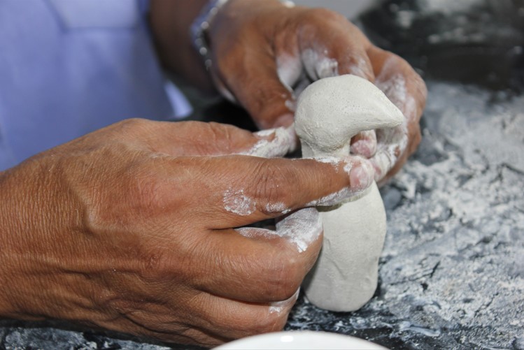 Artist shaping clay with hands
