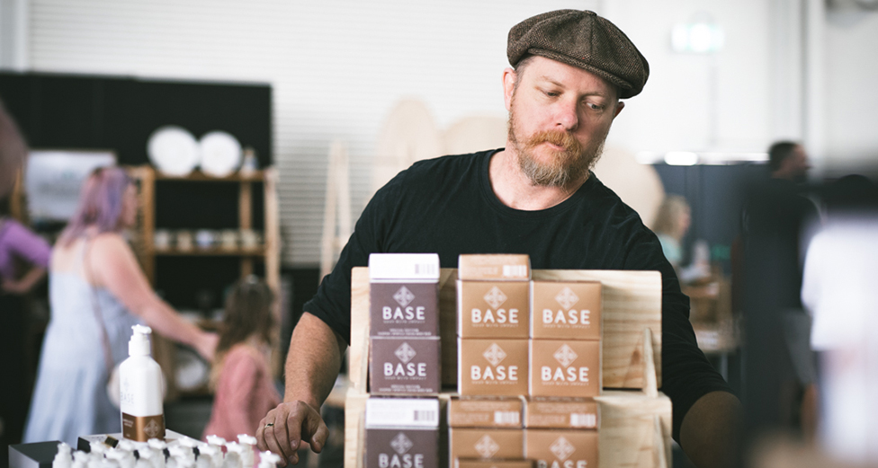 A man stacks bars of soaps in a store.