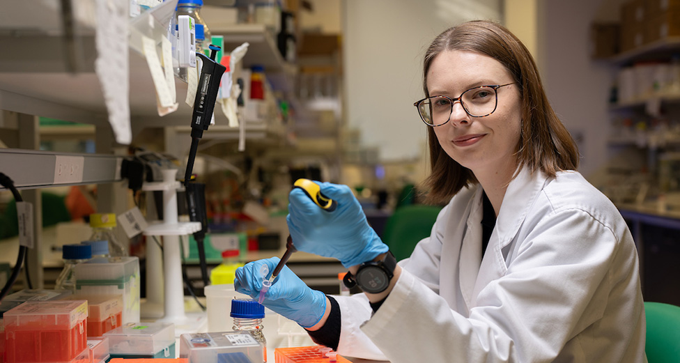 A female scientist in a white coat in a lab.