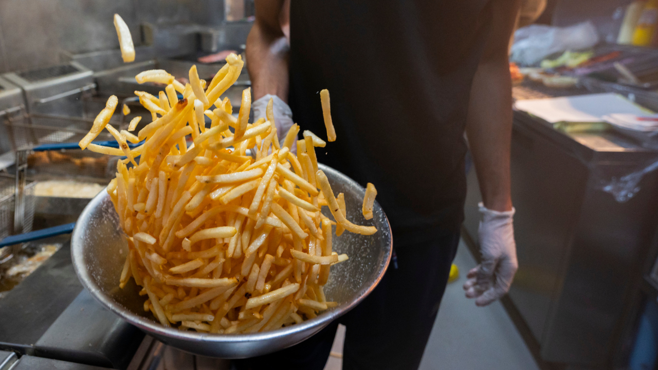 Image of chef tossing chips in a bowl.