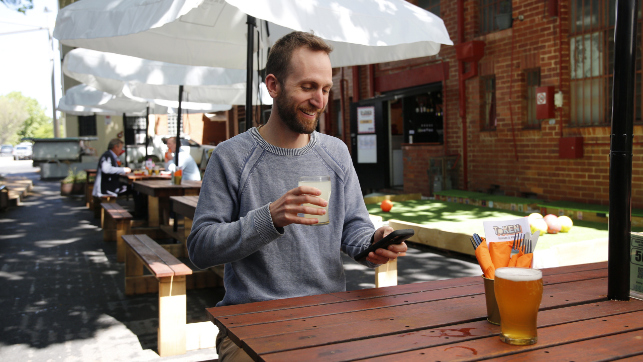 Man enjoys a drink in Reload's new outdoor dining area in Verity Lane 