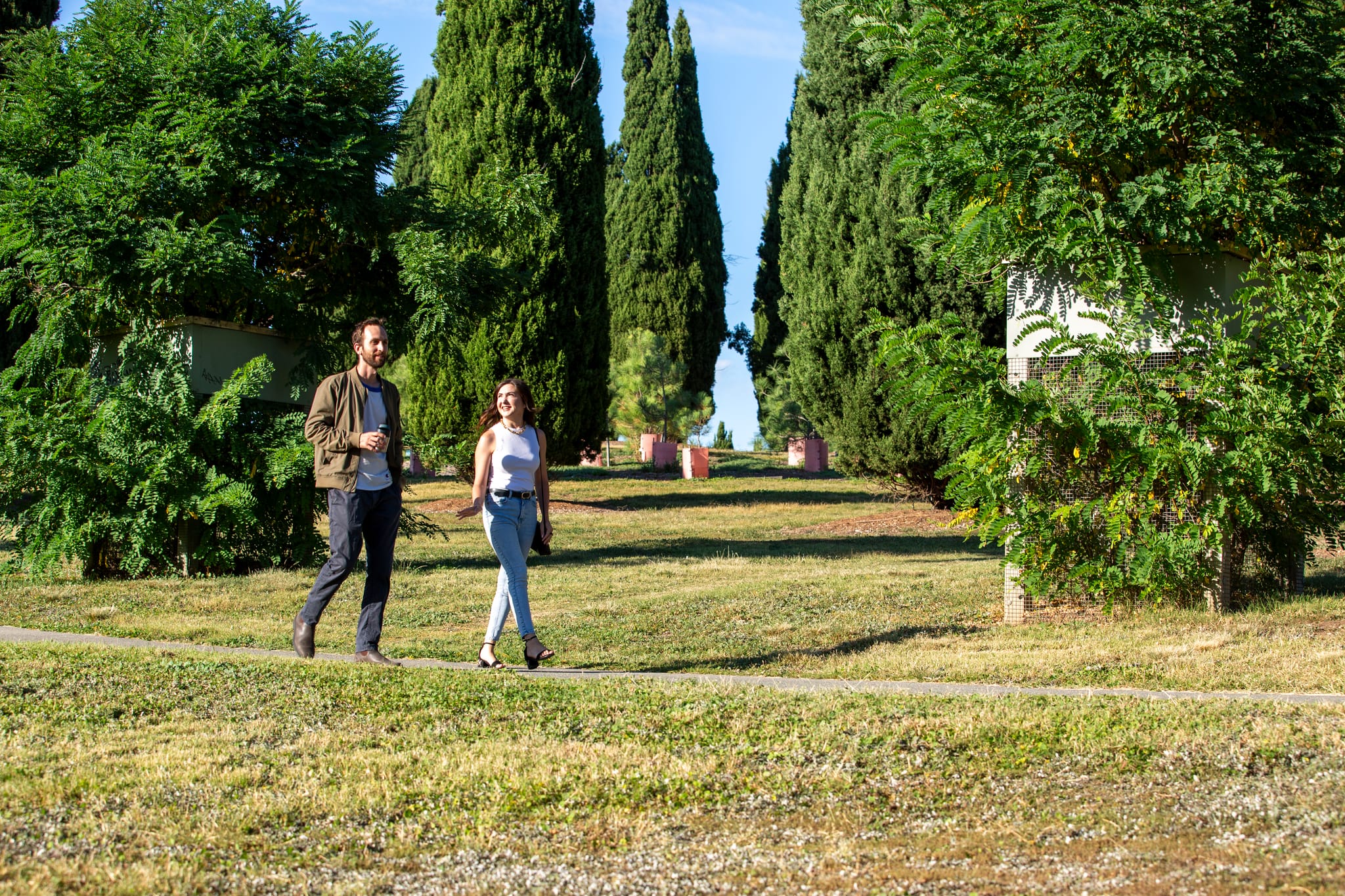 Two friends walking through City Hill park on a sunny day