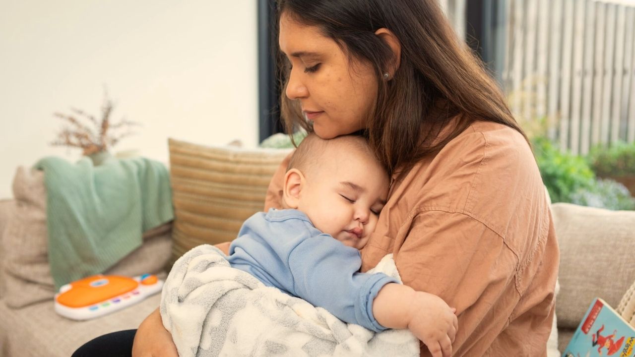 A person holds a sleeping baby.
