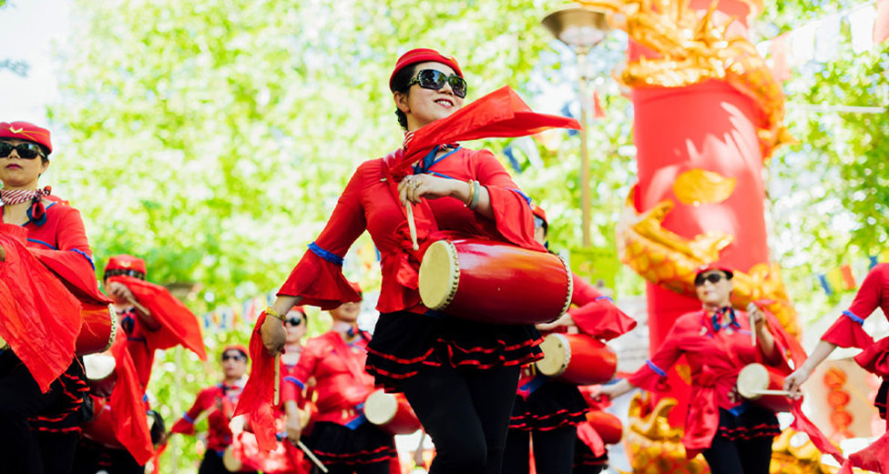 Women dressed in red march with drums