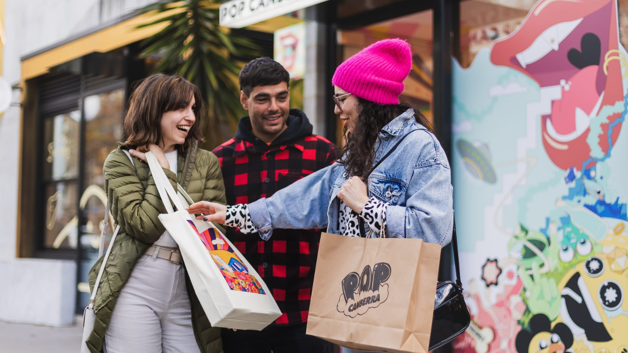 Three smiling friends on Lonsdale Street doing some shopping