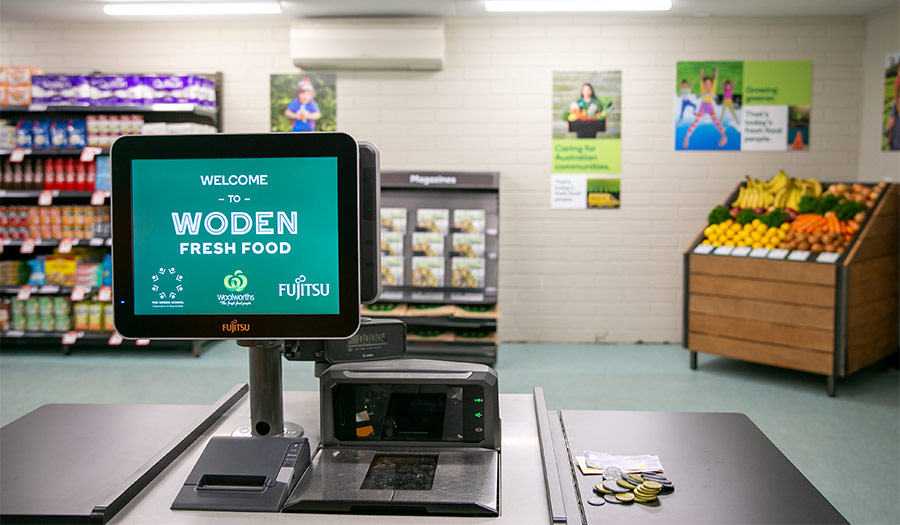 Checkout machine reading Woden Fresh Food with the store in the background