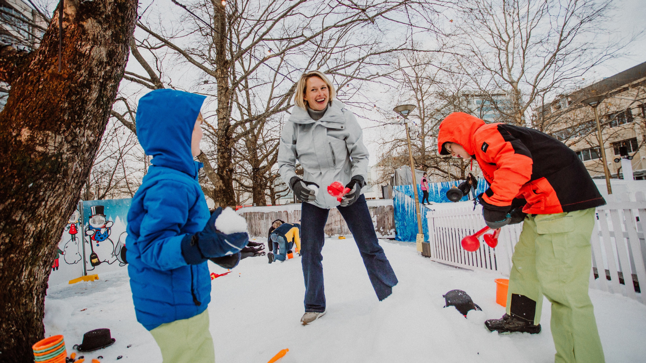 A family plays in the snow at Winter in the City