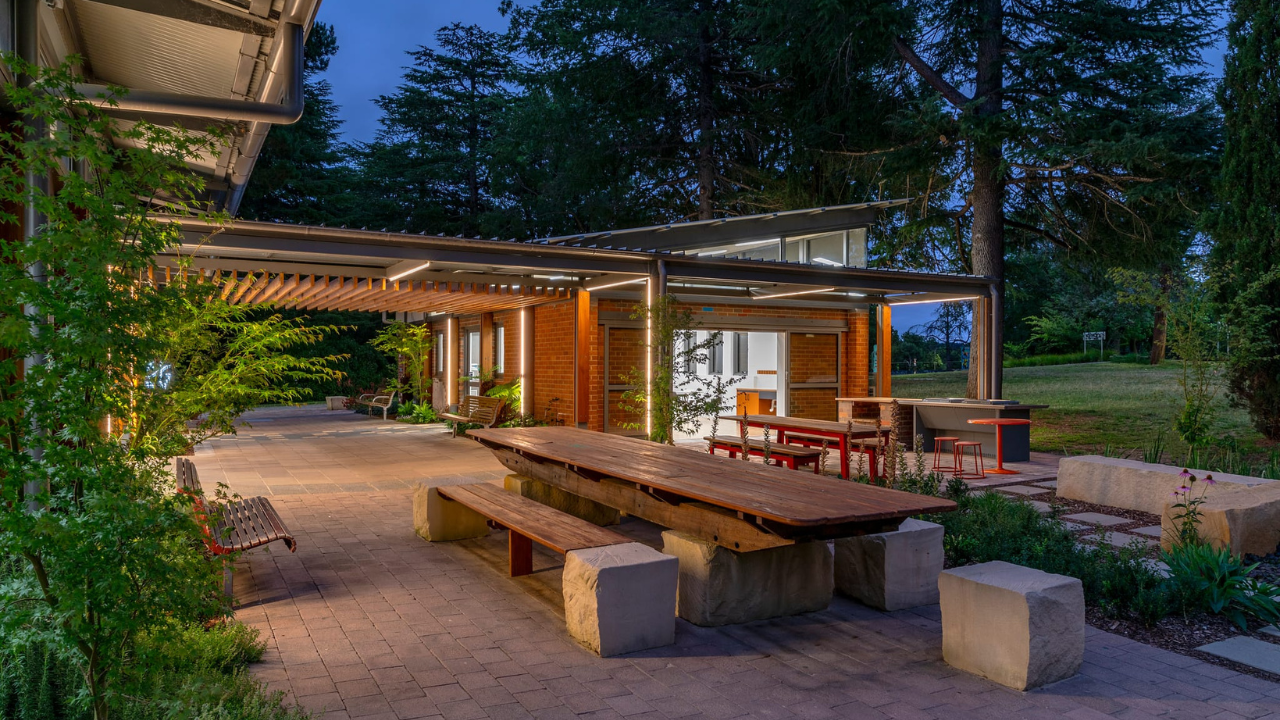 A photo of the Salthouse courtyard at night with the wooden table made from reclaimed wood.
